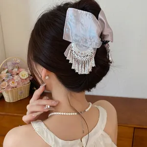 Elegante haarklem met bloemenprint strik en zilveren kwastje op een model zijwaarts