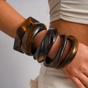 Detailed macro shot of vintage amber marble resin bangles on a woman's arm