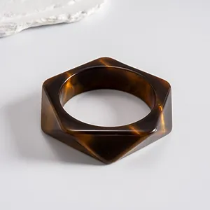 Close-up view of a vintage tortoiseshell resin geometric bangle with faceted edges