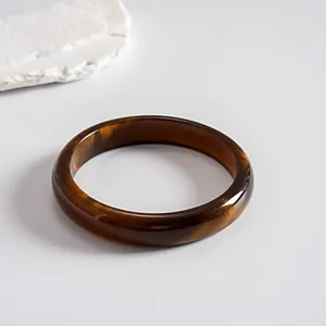 Detail shot of the amber resin bangle with subtle gold flecks and retro smudge effect