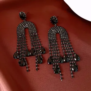 Detailed view of luxurious black rhinestone tassel earrings featuring teardrop crystal charms