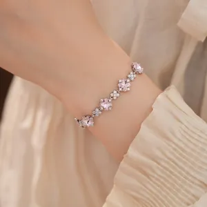 Elegante Nahaufnahme eines silbernen Blumenarmbands mit rosa Zirkonia am Handgelenk