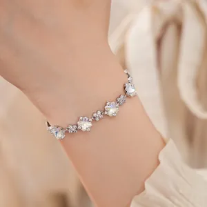 Detailaufnahme eines eleganten silbernen Blumenarmbands mit Zirkonia am Handgelenk