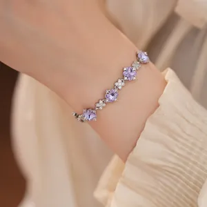Elegant silbernes Armband mit violetten Zirkonblüten und klaren Steinen am Handgelenk
