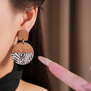 Macro view of the unique resin and wood patchwork earring with botanical pattern detail