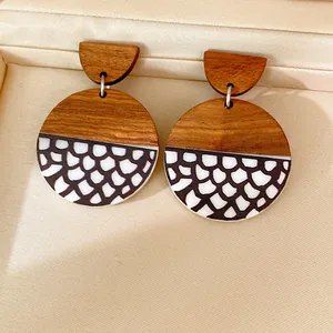 Close-up of retro ethnic round silver needle earrings made of wood and printed resin