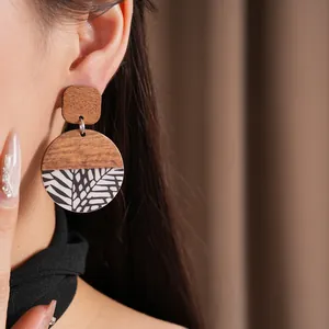 Macro view of vintage resin and wood earrings featuring a botanical leaf pattern