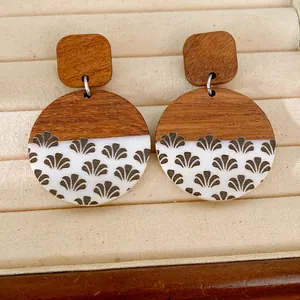 Detailed view of handmade wood and white resin circular earrings with grey fan pattern print