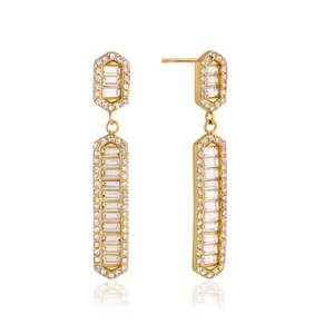 Eleganti orecchini pendenti in acciaio al titanio dorato con brillanti strass a baguette.