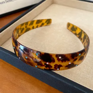 Close-up of French vintage leopard print acrylic headband with colorful rhinestones.