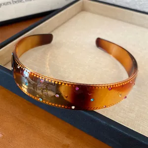 Macro view of a retro tortoiseshell acrylic headband decorated with colorful rhinestones