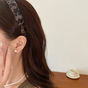 Detail of retro leopard print acrylic headband with colorful rhinestones on a model