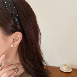 Close-up view of a French retro acrylic headband with colorful rhinestones on a model