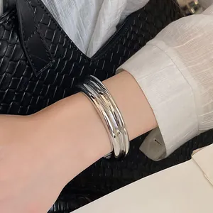 Close-up of minimalist silver metallic textured open cuff bangle on wrist