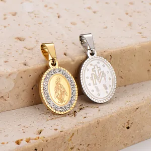 Primo piano di ciondoli religiosi ovali in acciaio inossidabile oro 18k e argento con cristalli.