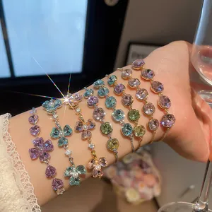 Close-up of multiple colorful crystal bracelets worn on a wrist with shiny zircon details.