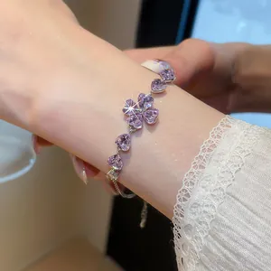 Macro shot of a sparkling purple heart-shaped zircon clover bracelet on an elegant wrist