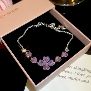 Detailed macro shot of silver bracelet with purple heart-shaped zircons in pink jewelry box