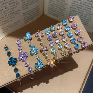 Detail view of various 18k gold plated bracelets with sparkling heart and flower zircons