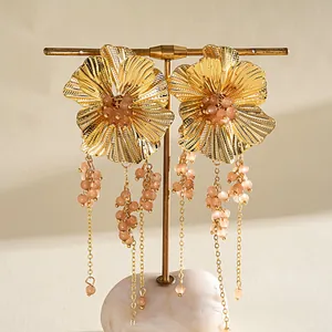 Vintage gouden bloemenoorbellen met kwastjes van perzikglasparels en zilveren studs.