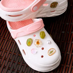 Artistieke set schoenbedeltjes van hars en droogbloemen op wit-roze clogs voor dames