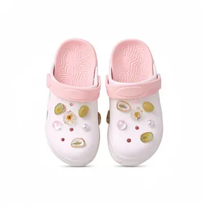 Stijlvolle witte klompsandalen met roze bandje en decoratieve bloemenharsbedeltjes