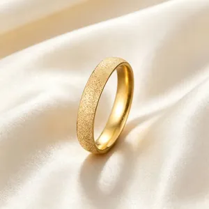 Close-up detail of a luxury gold frosted starry sky titanium steel ring on soft white silk