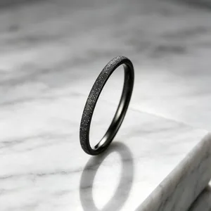 Macro view of a minimalist black frosted titanium steel ring with starry sky texture