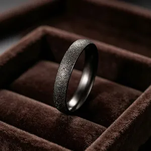 Close-up of minimalist matte black starry sky titanium steel ring with fine glitter.