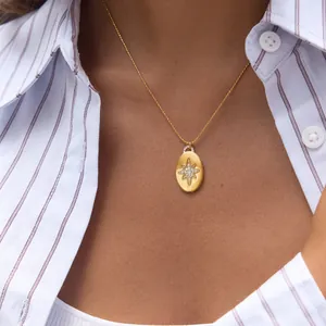 Detail view of 18K gold plated stainless steel necklace with star pendant on model