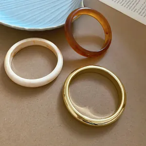 Minimalistische Armreifen aus Goldmetall, cremefarbenem Marmor und Acryl Bernstein