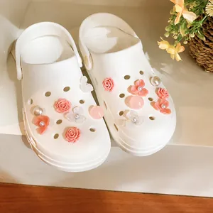 Eleganti ciondoli per scarpe fai-da-te con fiori e perle su sabot bianchi chic.