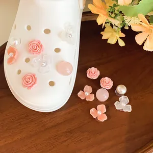 Dettaglio che mostra rose in resina rosa e ciondoli di perle per sabot da giardino