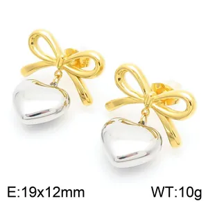 Detailed macro shot of stainless steel bow and heart earrings in gold and silver finish