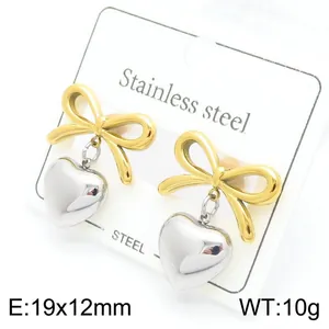 Detailed shot of gold bow and silver heart pendant earrings in stainless steel