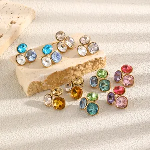 Detailweergave van de 18K vergulde geometrische oorbellen met kleurrijke zirkonia's