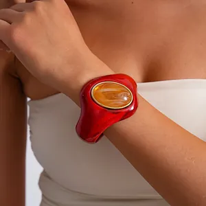 Dettaglio ravvicinato di bracciale rigido in acrilico marmorizzato rosso con resina