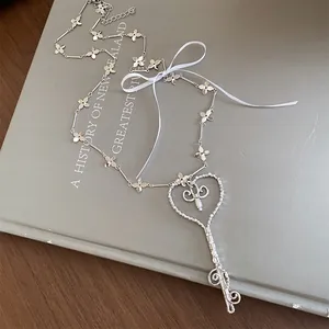 Detalle del collar de llave de corazón estilo ballet francés con flores y cinta blanca
