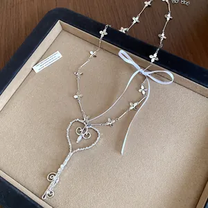 Vista detallada del collar con colgante de llave de corazón estilo ballet francés y perlas