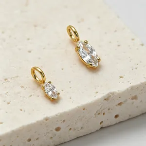 Makro-Detail von 14k vergoldeten Edelstahl-Anhängern mit Marquise-Zirkonia auf Steintextur