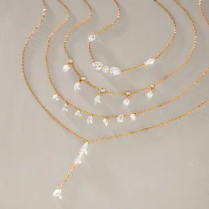 Detailed macro shot of several gold titanium steel necklaces featuring clear CZ stones.
