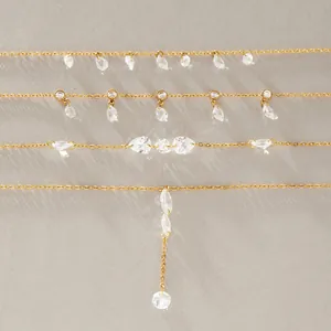Detail of titanium steel necklaces with sparkling clear CZ stone pendants in gold finish.