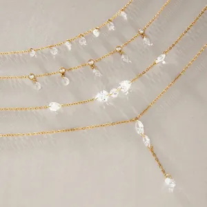 Macro view of gold titanium steel necklace with dangling teardrop zircons