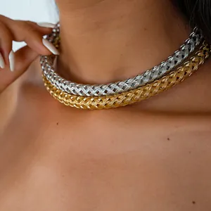 Vue détaillée de colliers ras du cou en métal tressé doré et argenté sur le cou d'un mannequin