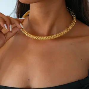 Vue détaillée d'un collier ras du cou élégant en métal tressé doré sur un mannequin