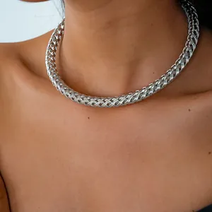 Gros plan d'un collier ras du cou en métal tressé argenté montrant sa texture tissée