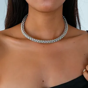 Gros plan d'un collier ras du cou en métal argenté tressé avec texture géométrique