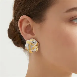 Elegant two-tone gold and silver woven lattice button stud earrings shown on model