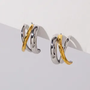 Macro view of minimalist two-tone stainless steel cross hoop earrings for women