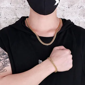 Close-up of 8mm gold stainless steel Cuban link necklace and bracelet set on model